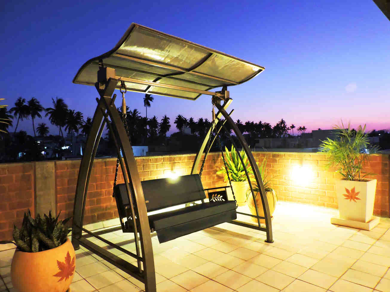 A shaded terrace swing at dusk